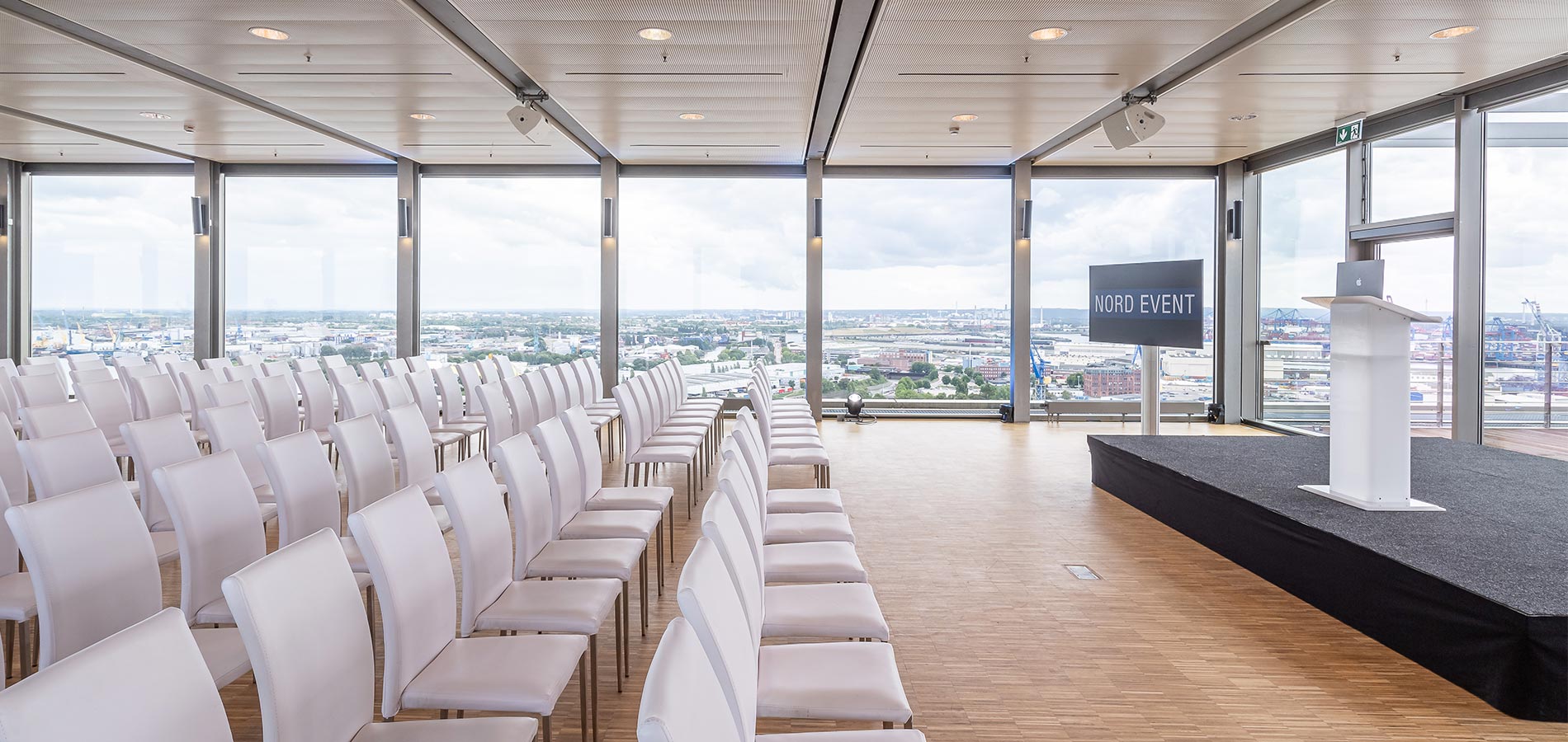 Eventlocation in Hamburg von NORD EVENT - Penthouse Elb-Panorama - Tagung - Stuhlreihen und Buehne mit Aussicht