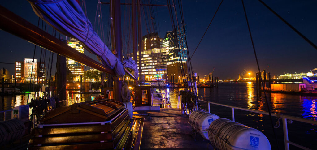 Weihnachtliche Teambuildings in Hamburg mit NORD EVENT - Weihnachtstoern - Schiff am Abend mit Blick auf die Elbphilharmonie